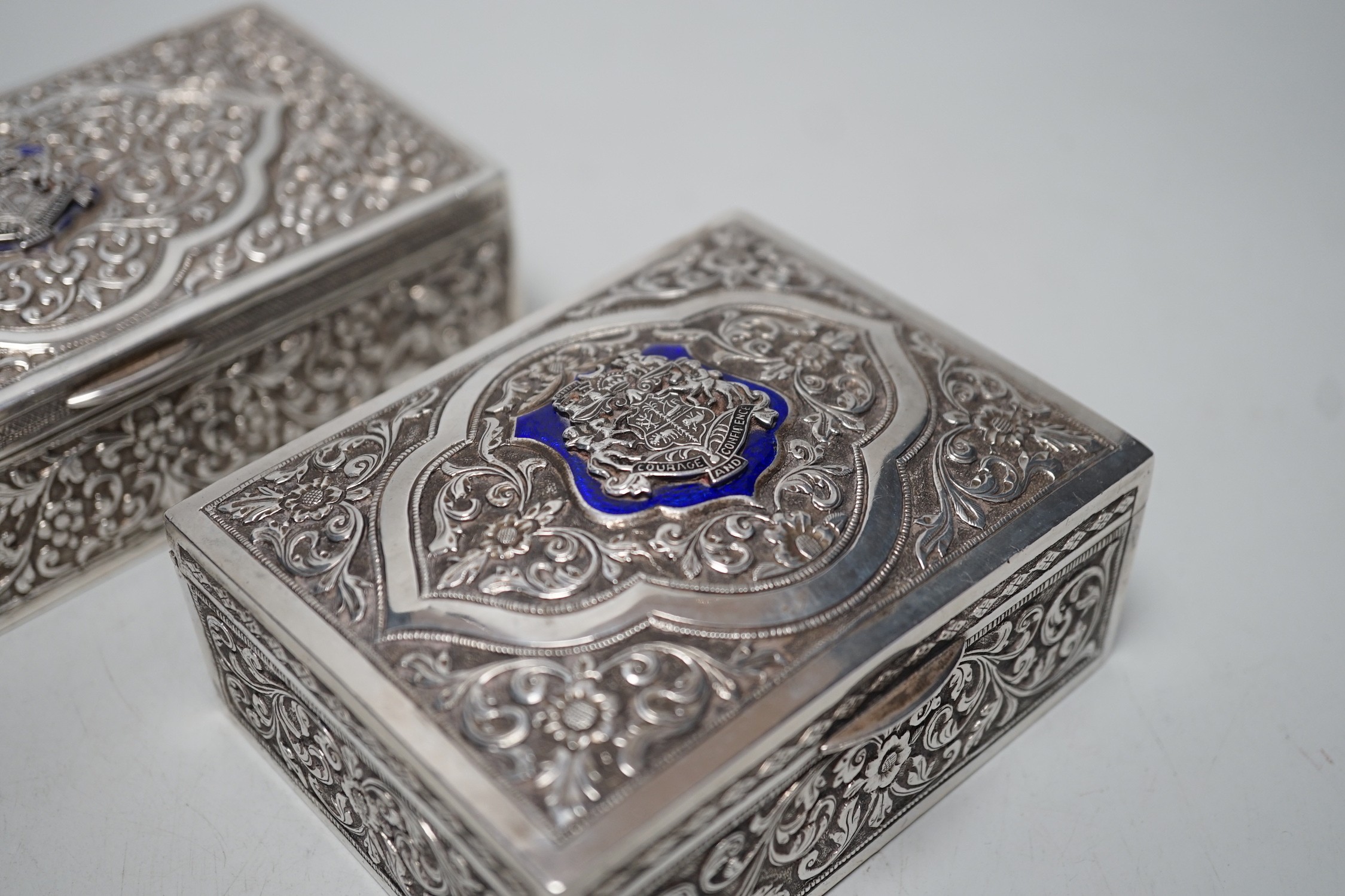 Two early 20th century Indian embossed white metal rectangular boxes, both applied with the enamelled rest of the Bhuj Kutch Gujarat, largest 14.2cm